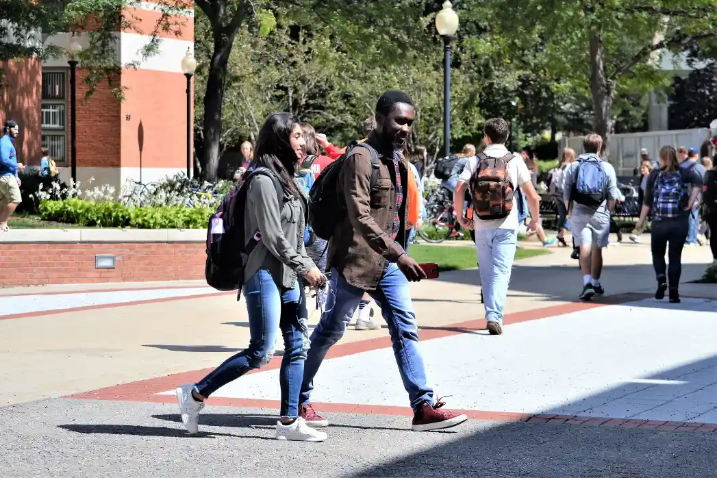 Diverse college students on campus walking to their classes for a higher education